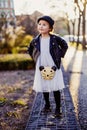 Little girl lookig aside with a cat hat walking in the city Royalty Free Stock Photo