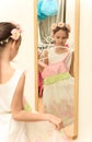 Little girl looking in mirror with new dress in hands Royalty Free Stock Photo