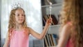 Little girl looking at mirror reflection, wearing fancy princess dress, magic Royalty Free Stock Photo