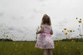 Little Girl looking out at a flower field