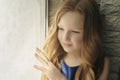 Little girl looking out the window through the blinds. Royalty Free Stock Photo