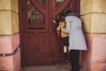 Little girl looking out the window of old wooden door with her mom Royalty Free Stock Photo