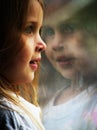 A little girl looking out a window Royalty Free Stock Photo