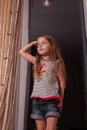 Little girl looking out window while standing on windowsill Royalty Free Stock Photo