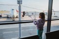 Little girl is looking to airplanes in airport waiting lounge in Moscow