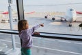 Little girl is looking to airplanes in airport waiting lounge in Moscow Royalty Free Stock Photo