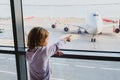 Little girl is looking to airplanes in airport waiting lounge in Moscow Royalty Free Stock Photo