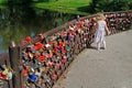 Little girl looking at wedding locks on fence in Botanical garden named Tsitsin in Moscow