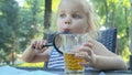 Little girl looks into the lens around. Close-up of blonde girl studying the world around her looking at it through magnifying