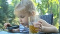 Little girl looks into the lens around. Close-up of blonde girl studying the world around her looking at it through magnifying