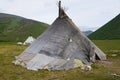 A little girl looks out of the tent on the reindeer herder camp