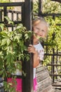 Little girl looks out of a wooden pergola Royalty Free Stock Photo