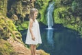 Little girl looks at the smiling water by a river