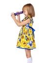 A little girl looks into a telescope or in a kaleidoscope. Royalty Free Stock Photo