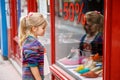 Little Girl looks at the window near the shopping center. Adorable happy child looking on shoes in store window. Royalty Free Stock Photo