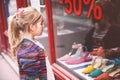 Little Girl looks at the window near the shopping center. Happy child looking on shoes in store window. Royalty Free Stock Photo