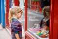 Little Girl looks at the window near the shopping center. Adorable happy child looking on shoes in store window. Royalty Free Stock Photo