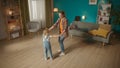 Little girl and loving mom holding hands dancing in the living room. The family is having fun together, enjoying Royalty Free Stock Photo