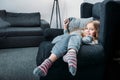 Little girl lying in armchair with pillow and looking at camera Royalty Free Stock Photo