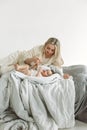 A little girl is lying in bed with cookies in her hands. The mother is lying next to her daughter, holding a pacifier in her hands Royalty Free Stock Photo