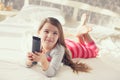 Little girl lying in bed with a remote control TV Royalty Free Stock Photo