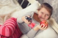 Little girl lying in bed with a remote control TV Royalty Free Stock Photo