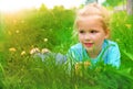 Little girl lying on grass lawn. Summer fun outdoors. Happy child enjoying on grass field and dreaming Royalty Free Stock Photo