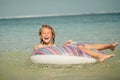 Little girl lying on the inflatable rubber circle in the sea