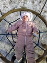 Little girl lying on swing in snowy winter forest Royalty Free Stock Photo