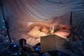 Little girl lying in a teepee, playing with the flashlight Royalty Free Stock Photo