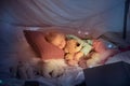 Little girl lying in a teepee, sleeping with the flashlight Royalty Free Stock Photo