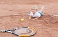 The little girl lying on the tennis court. Little girl, tennis ball and racket Royalty Free Stock Photo