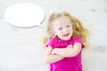 Little girl lying on white wooden floor with a speech bubble above her head Royalty Free Stock Photo