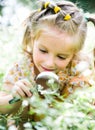 Little girl with magnifying glass looks at flower Royalty Free Stock Photo