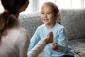 Little girl make hand gesture learn sign language with mom