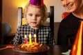 Little girl make a wish before blow out the candles on her birthday cake Royalty Free Stock Photo