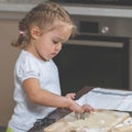 Little girl makes cookie from a dough in the kitchen at home Royalty Free Stock Photo
