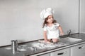 Little girl makes dough on kitchen with rolling pin Royalty Free Stock Photo