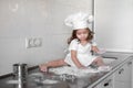 Little girl makes dough on kitchen with rolling pin Royalty Free Stock Photo