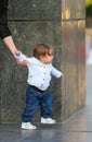 Little girl makes first independent steps being hold mother hand