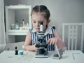 Little girl makes scientific experiments with chemical and biological products in her home laboratory. Royalty Free Stock Photo