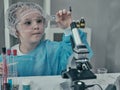 Little girl makes scientific experiments with chemical and biological products in her home laboratory. Royalty Free Stock Photo