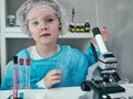 Little girl makes scientific experiments with chemical and biological products in her home laboratory. Royalty Free Stock Photo