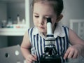 Little girl makes scientific experiments with chemical and biological products in her home laboratory. Royalty Free Stock Photo