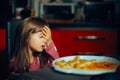 Little Girl Making a Face palm Gesture at the Dinner Table Royalty Free Stock Photo