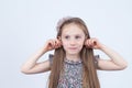 Little girl is making faces. Funny expressions. Having fun. Preschooler in dress on white background. Royalty Free Stock Photo