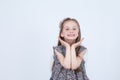 Little girl is making faces. Funny and happy expressions. Having fun. Preschooler in dress on white background. Royalty Free Stock Photo