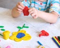 Little girl making flower with center earth planet shape from plasticine, Home Education game with clay. Early development and