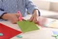 Little girl making greeting card at table, closeup. Creative hobby