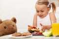 Little girl making a sandwich to her teddy bear Royalty Free Stock Photo